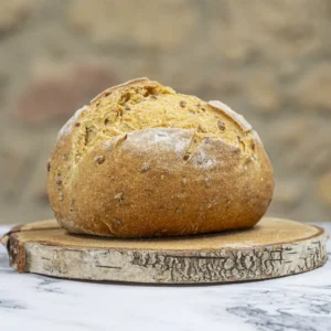 Pan de maíz sin gluten con pipas de girasol sobre una base de madera, fondo rústico de piedra