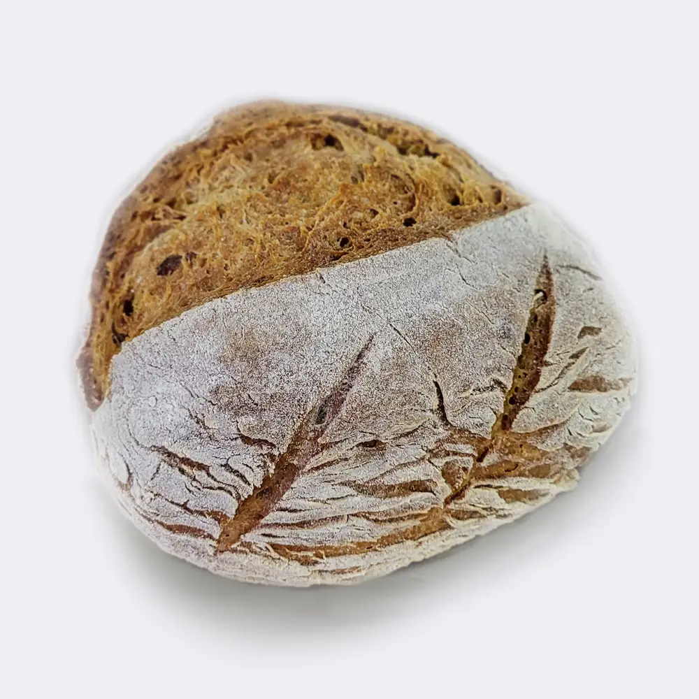Imagen de un pan redondo con una textura rústica y dorada. El pan se encuentra sobre un fondo blanco, lo que permite resaltar sus características artesanales y naturales. La presentación es simple pero elegante, destacando la calidad y el aspecto apetitoso del pan